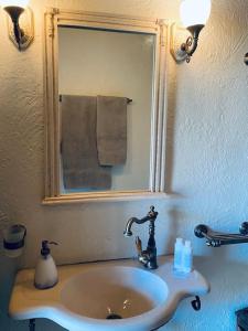 a sink in a bathroom with a mirror and a mirror at Aelia Cottage House in Khrónia +26 photos
