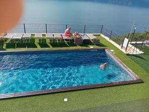 a person swimming in a swimming pool on top of a building at LE TERRAZZE SUL GARDA RELAIS in Biaza