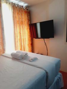 1 dormitorio con 1 cama con toallas y ventana en Delta Charlie Staycation CDO, en Cagayan de Oro