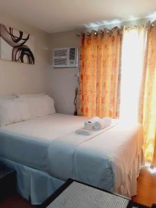 1 dormitorio con 2 camas y ventana en Delta Charlie Staycation CDO, en Cagayan de Oro