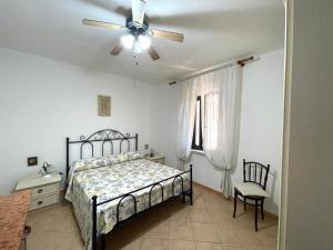 una camera da letto con un letto e un ventilatore a soffitto di La Casa dei Nodi - Santa Teresa di Gallura a Santa Teresa di Gallura