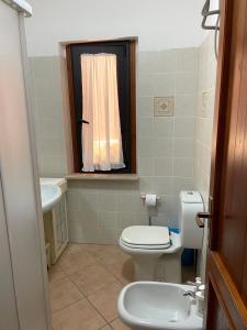 un piccolo bagno con un water e un lavandino di La Casa dei Nodi - Santa Teresa di Gallura a Santa Teresa di Gallura Altre 37 foto