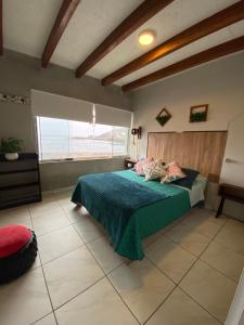 een slaapkamer met een bed en een groot raam bij BAHÍA SUR HOUSE - San Bartolo in San Bartolo
