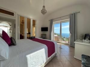 1 dormitorio con cama y vistas al océano en MARVELOUS SEA VIEW VILLA, en Capri