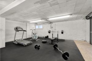 a gym with a treadmill and weights in a room at Villa Rose - Padel - Piscine - Cinéma & Poker Room in Saint-Jory