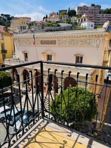 balkon z widokiem na budynek w obiekcie Hôtel Narev's w Mentonie