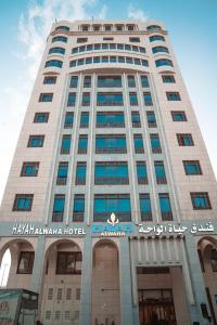 a tall building with a sign on the front of it at Hayah Al Waha Hotel in Al Madinah