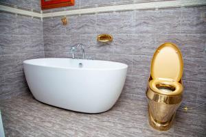 a bathroom with a gold toilet and a sink at appartement 2 crepin in Pointe-Noire