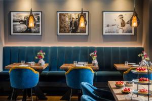 a restaurant with two tables and blue chairs at Hotel Atlantic - Kopf aus, Herz an! in Westerland