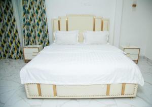 a bedroom with a large bed with white sheets and pillows at appartement 2 crepin in Pointe-Noire