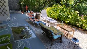 a group of chairs and tables in a garden at Stomio 4 Seasons Relaxing Apartment in Stomio