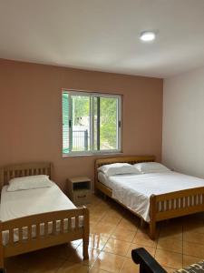 2 camas num quarto com uma janela em Private House Velipoj em Velipojë