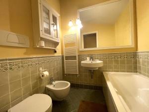 y baño con aseo, lavabo y bañera. en Magenta Apartment, en Florencia