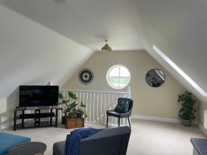 a living room with a couch and a tv at Cheshire Retreat in Middlewich