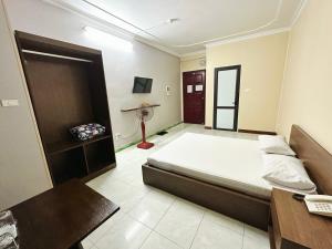 a bedroom with a bed and a desk and a television at Đình Vũ 3 MOTEL in Hai Phong