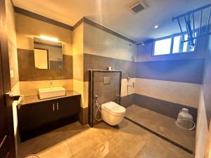 a bathroom with a toilet and a sink at Luxe Hotel Thekkady in Thekkady