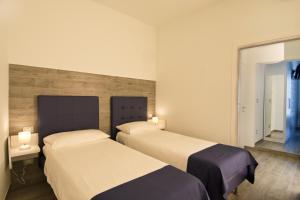 two beds in a hotel room with two lamps at Locanda degli Angioini Locazione Turistica in Mola di Bari