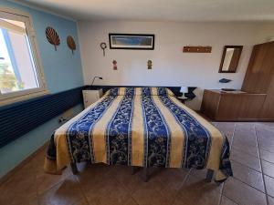 a bedroom with a bed with a blue and yellow blanket at Casa delle Salinelle in Lascari