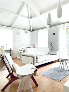 ein Wohnzimmer mit einem weißen Sofa und einem Tisch in der Unterkunft Design Holiday Home in Ermelo