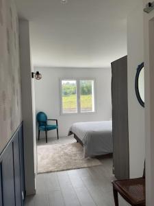 a bedroom with a bed and a chair and a window at Maison à louer au pays basque in Anglet +30 photos