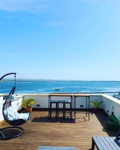 einen Balkon mit einem Tisch, Stühlen und Meerblick in der Unterkunft A-mare Exclusive Rooms & Suites in Taranto
