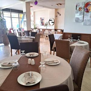 um restaurante com mesas e cadeiras com pratos e guardanapos em Hotel Buenavista Dakhla em Dakhla