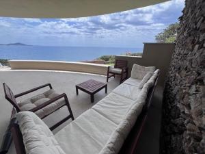 a balcony with couches and a view of the ocean at Villa Capo Boi in Villasimius
