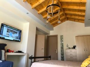 a bedroom with a bed and a tv on the wall at Quiet Guest house in Moúdhros