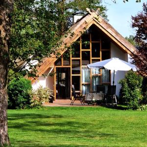 een huis met een paraplu en een tafel en stoelen bij Kauperhaus in Burg