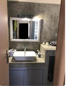 a bathroom with a sink and a mirror at Quiet Guest house in Moúdhros
