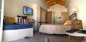 a bedroom with a bed and a desk and a table at Quiet Guest house in Moúdhros