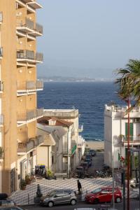 uma vista para uma rua com edifícios e o oceano em Appartamento al Mare Sant’Agata em Messina