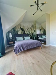 a bedroom with a bed and a painting on the wall at Zacisze in Kamień Pomorski