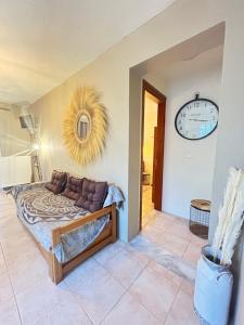 1 dormitorio con 1 cama y reloj en la pared en Natura Bungalows en Limenas