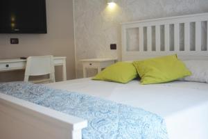 a bedroom with a white bed with two yellow pillows at Villa Anita - appartamento green in Pescara