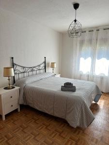 a bedroom with a bed and two lamps and two windows at Escondite de Julia in Mijares
