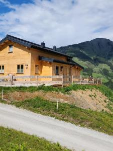 a wooden house on a hill next to a road at Lipphütte Top Lage mit traumhafter Aussicht in Rauris