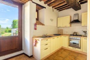 cocina con armarios amarillos y ventana grande en Casa Montecastelli Sopra/Terra, en Monte Castelli