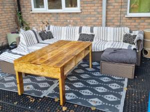 Beautiful guest house في Longham: طاولة خشبية وكوبين على الفناء