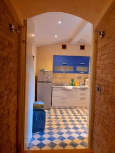cocina con armarios azules y suelo a cuadros en "Il Pollaio" guests house, en Panicale