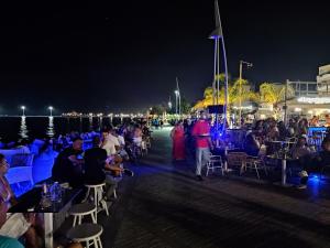 a crowd of people sitting at tables on the beach at night at Delphitea Philoxenia in Itea