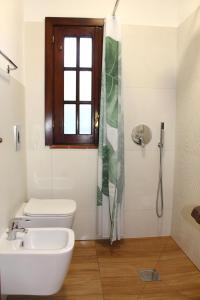 een badkamer met een toilet, een wastafel en een raam bij mare, sole e relax a 5 km da Cefalu' in Cefalù