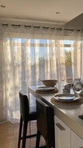 een keuken met een tafel met stoelen en een raam bij Pop Bohèm en Camargue maison atypique 135m2 in Arles