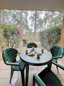 a table and chairs on a patio at Appartement à 2 pas océan et lac in Lacanau