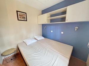 a small bed in a room with a blue wall at Appartement à 2 pas océan et lac in Lacanau +20 photos