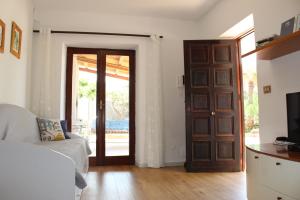 een woonkamer met een deur en een bank bij mare, sole e relax a 5 km da Cefalu' in Cefalù