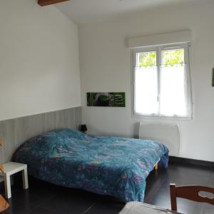 a bedroom with a bed and a window at Studio entre terre et mer in Saint-Romain-de-Benet