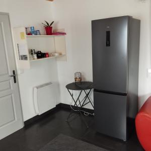 a refrigerator in a room with a small table at Studio entre terre et mer in Saint-Romain-de-Benet