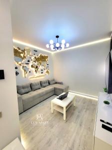 una sala de estar con sofá y un mapa mundial en la pared en Lux апартаменты в новом центре Караганды, en Karagandá