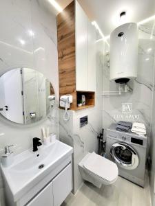 Un baño con lavabo y lavadora. en Lux апартаменты в новом центре Караганды, en Karagandá 4 fotos más